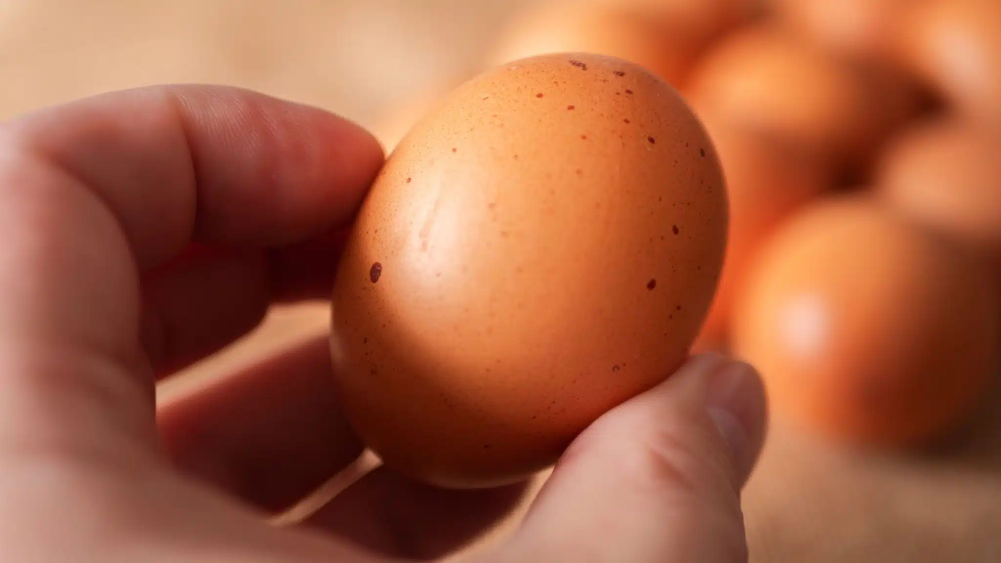 Main retirant une tache rouge d'un jaune d'œuf avec une cuillère