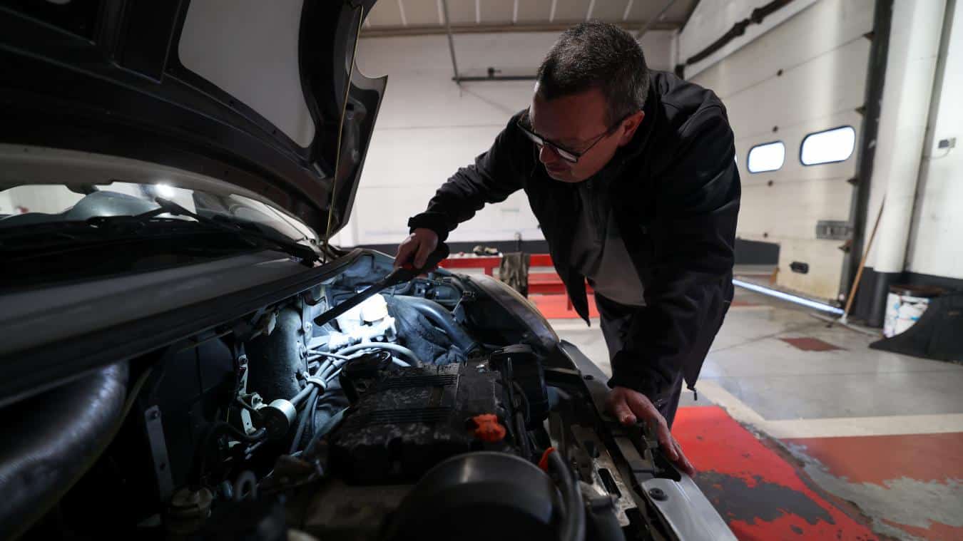 Automobiliste vérifiant son véhicule ancien