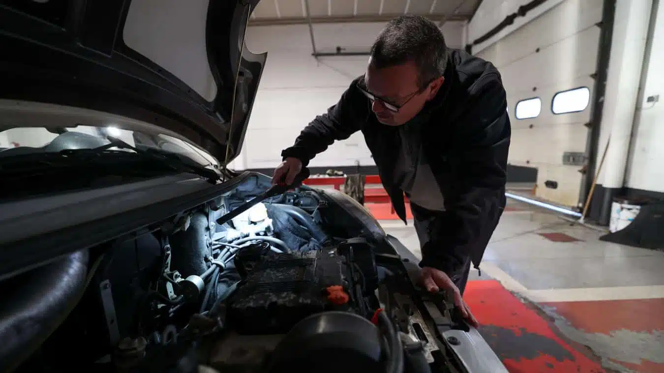 Automobiliste vérifiant son véhicule ancien