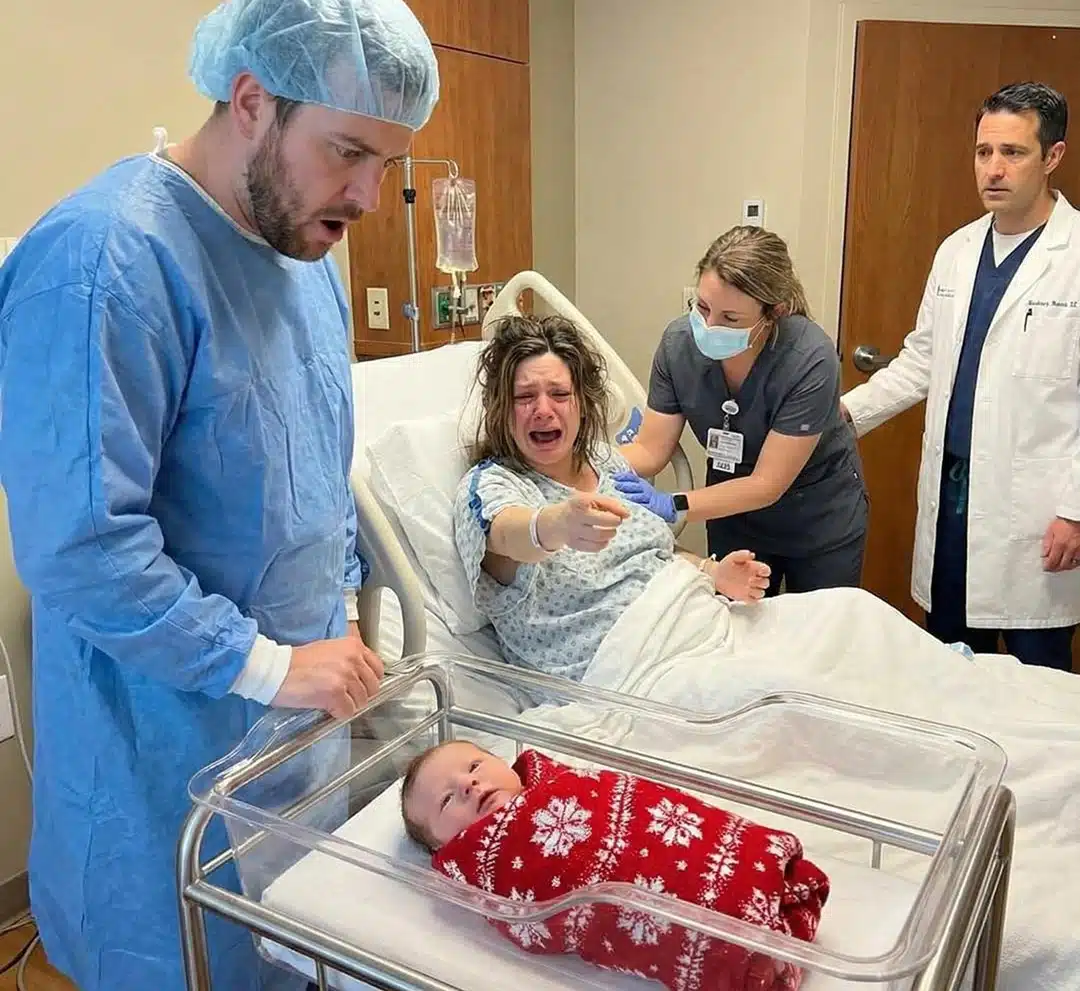 Mains d'une femme tenant délicatement des petits vêtements bleus de bébé.