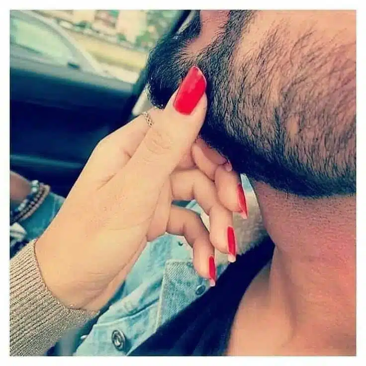 Main féminine touchant doucement le visage masculin