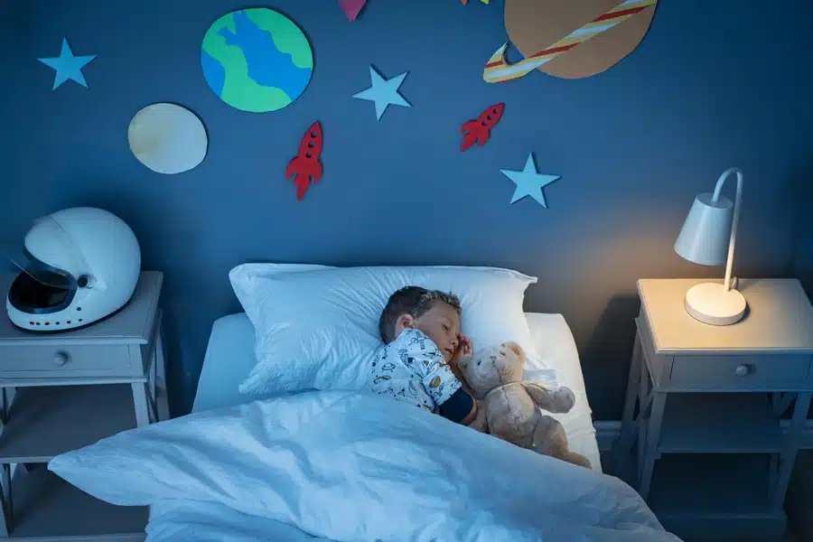 Enfant rêvant dans une chambre décorée sur le thème spatial