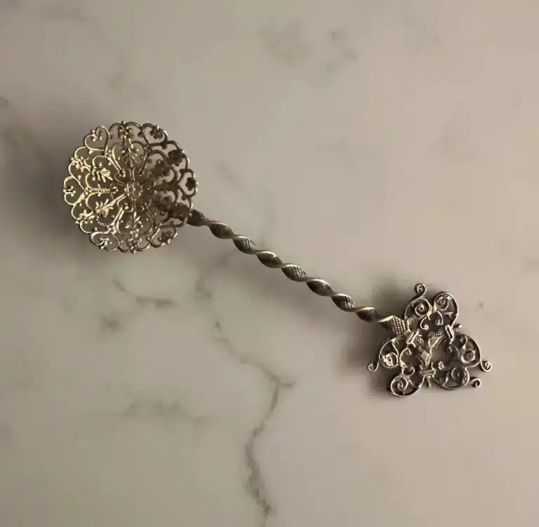 Cuillère à bonbons posée sur un napperon, détail