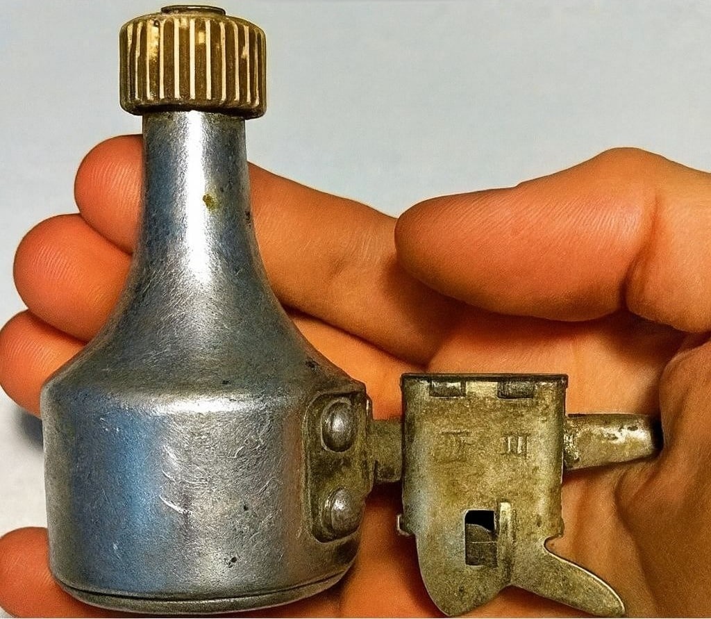 Collection d'objets vintage rouillés trouvés en extérieur, dont une dynamo, posés sur une surface en bois.