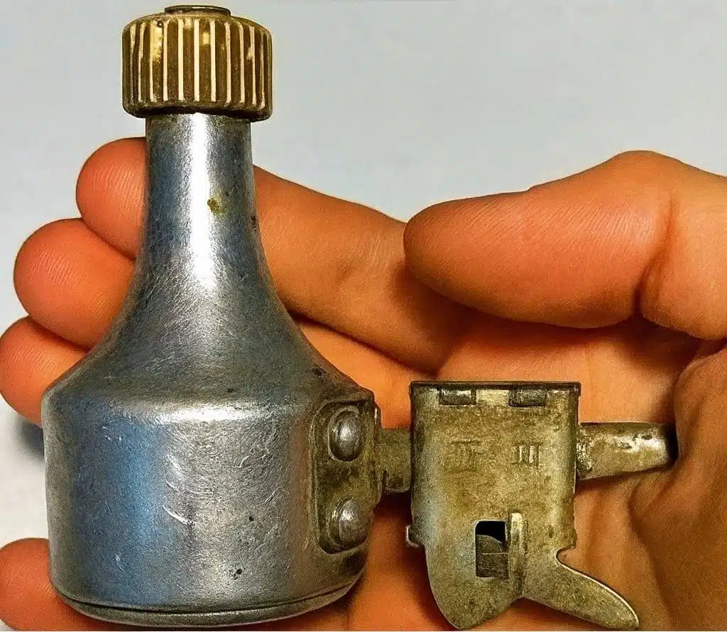 Collection d'objets vintage rouillés trouvés en extérieur, dont une dynamo, posés sur une surface en bois.