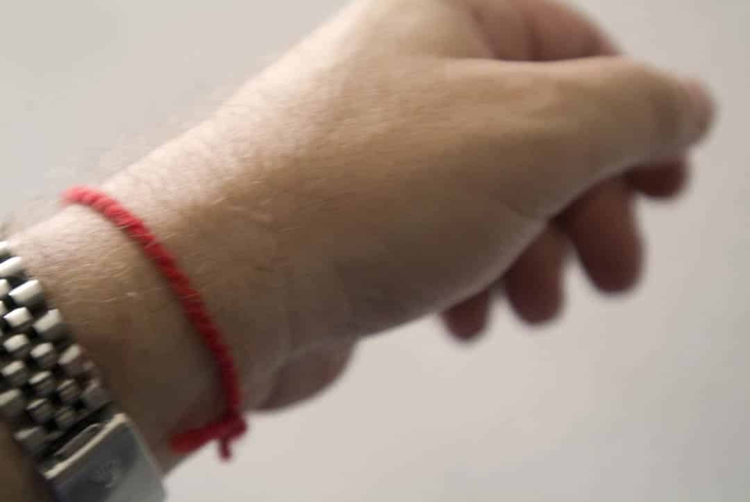 Femme méditant avec un bracelet rouge