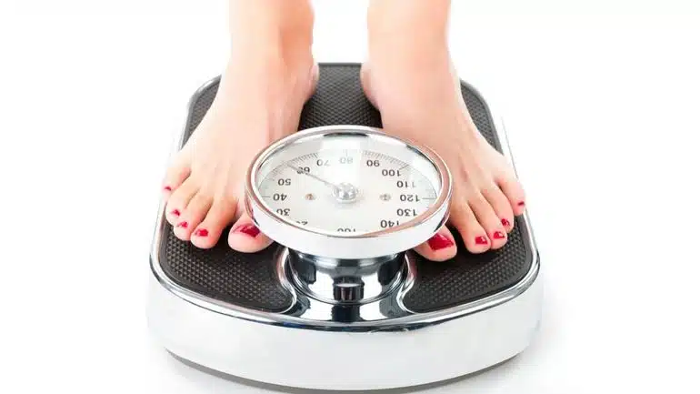 Personne mesurant son tour de taille avec un mètre ruban