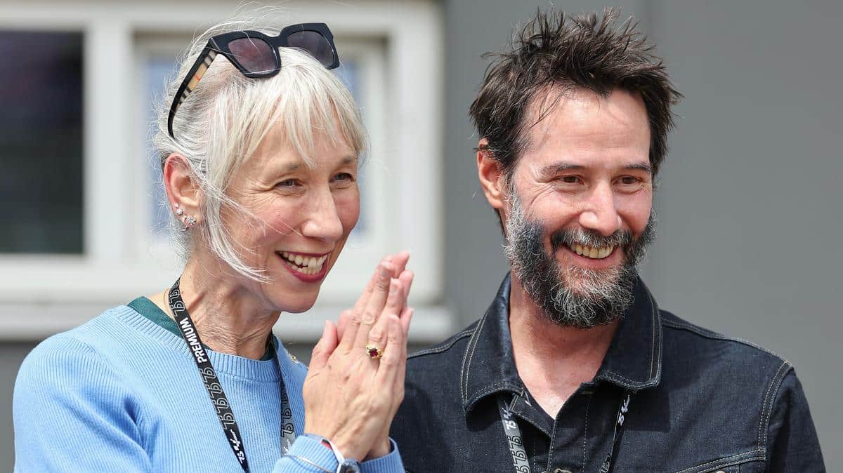 Keanu Reeves et Alexandra Grant se tenant la main, unis et sereins