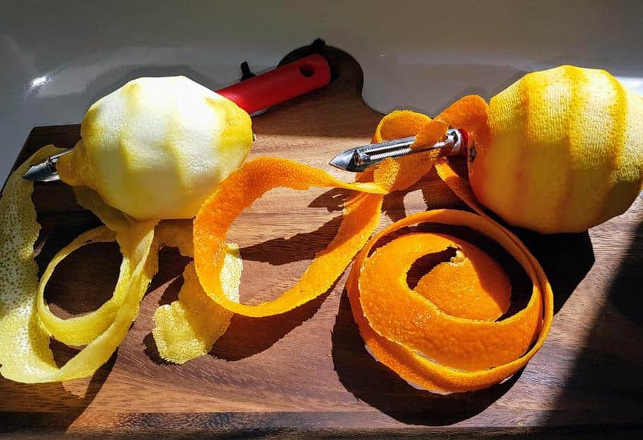 &Eacute;corces d'orange fra&icirc;ches sur une planche en bois