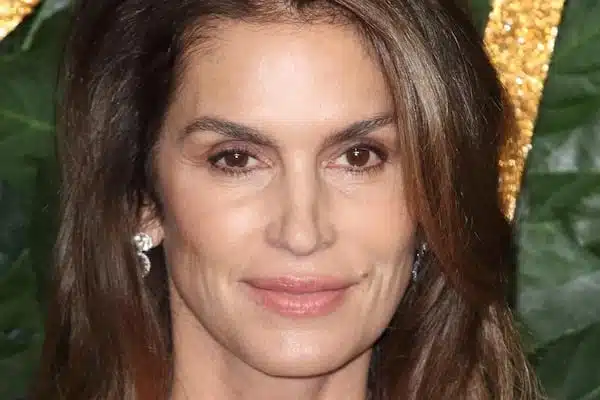 Cindy Crawford souriante, arborant des cheveux légèrement argentés avec naturel