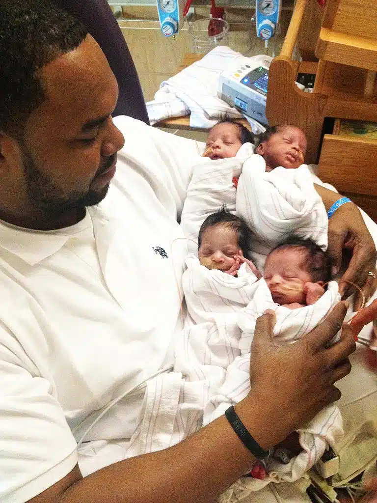 Père avec ses quadruplés nouveau-nés