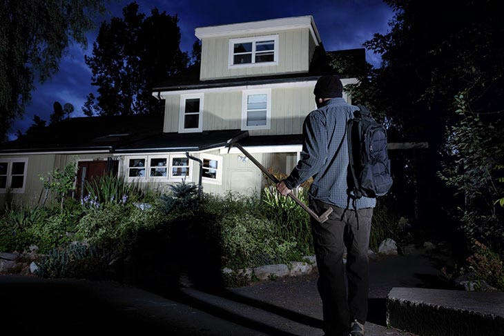 Cambrioleur sur le point de s’introduire dans une maison