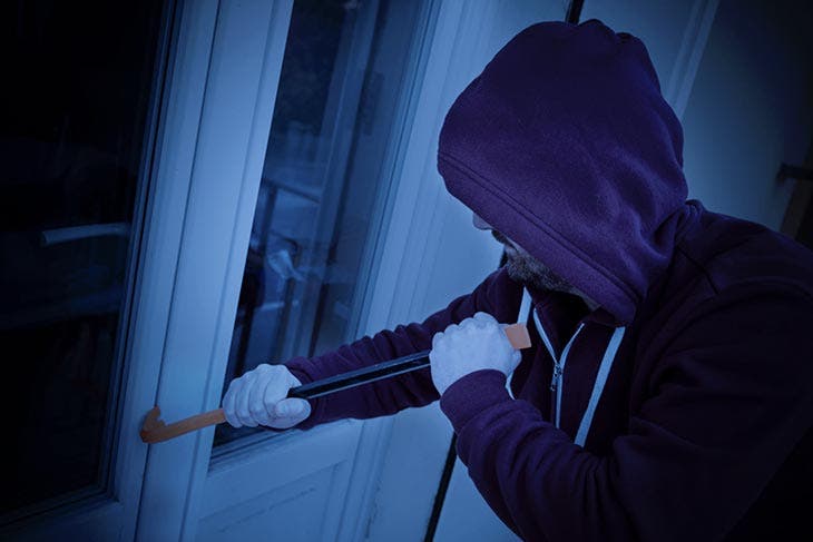 Cambrioleur utilisant un pied de biche pour ouvrir une porte