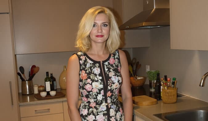 Femme regardant par l'entreb&acirc;illement d'une porte d'entr&eacute;e, expression inqui&egrave;te