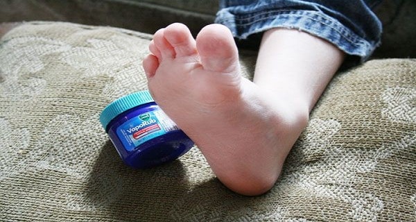 Personne appliquant du Vicks VapoRub sur son pied