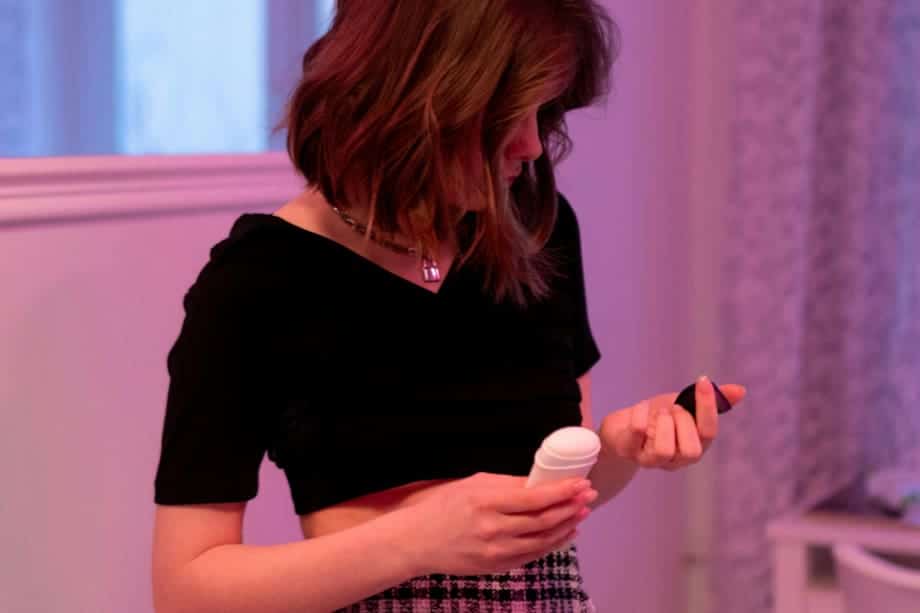 Femme appliquant du d&eacute;odorant en spray sous son bras