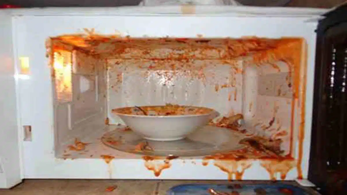 Micro-ondes avec des éclaboussures de nourriture sur les parois