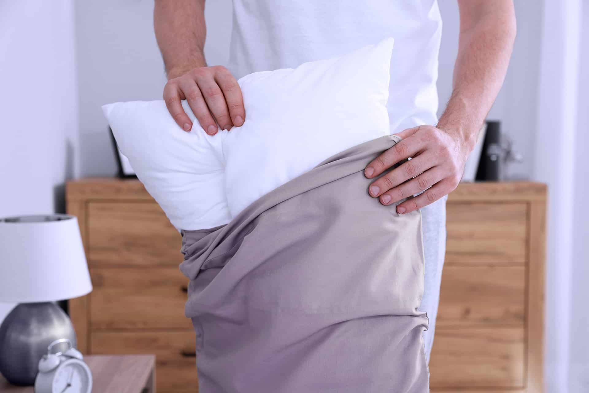 Main caressant un oreiller fraîchement lavé