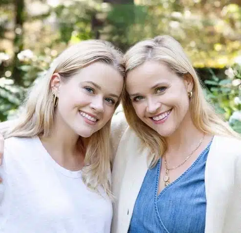 Reese Witherspoon tenant un livre, dans un cadre cosy