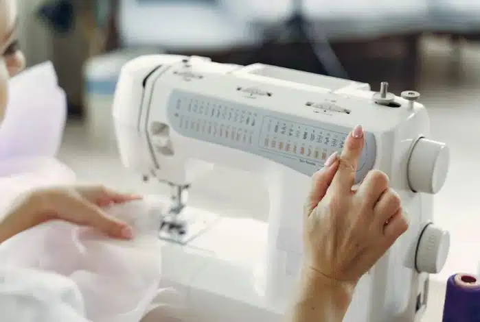 Une femme en train de coudre à la main, concentrée sur son ouvrage