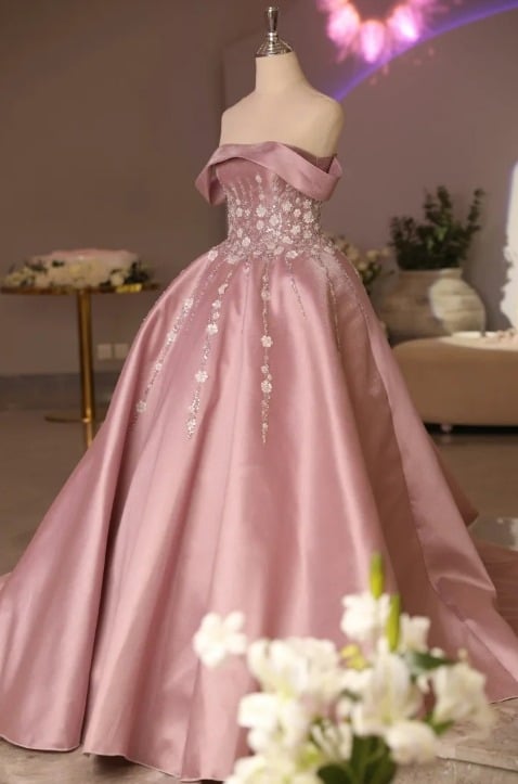 D&eacute;tail d'une robe de mari&eacute;e rose p&acirc;le, avec des broderies et des perles