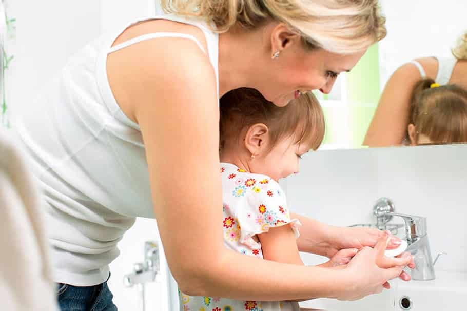 Femme se lavant les mains sous un robinet