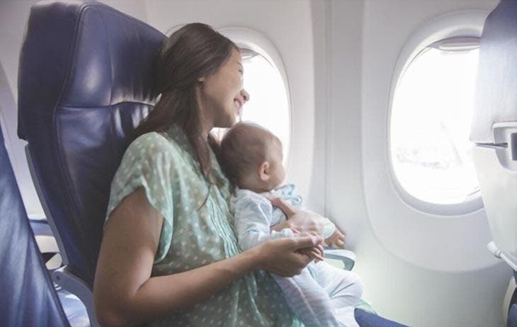 Une femme assise avec son bébé dans l'avion