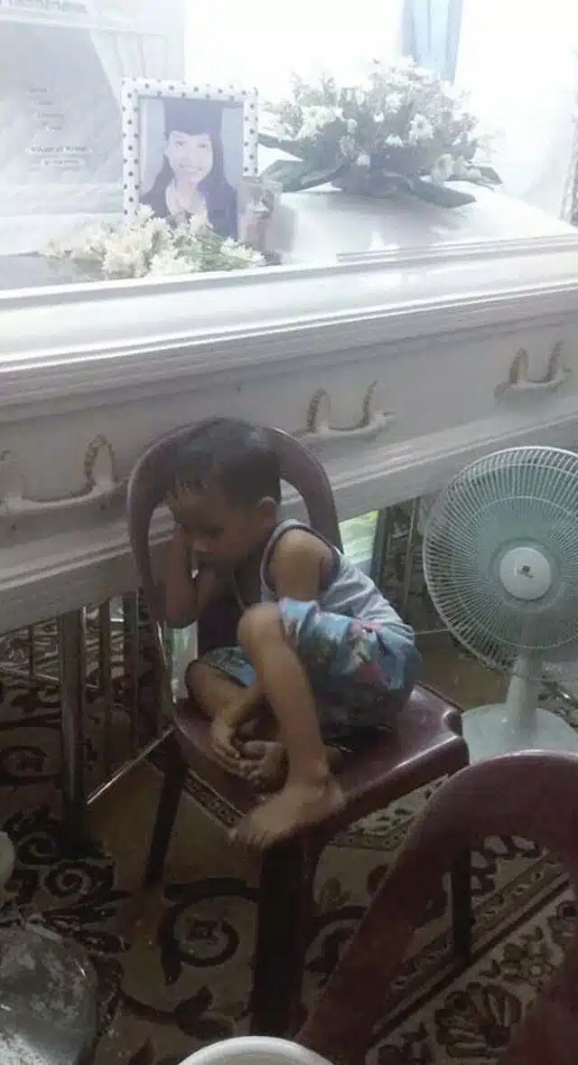 Un enfant enlacant tendrement un cercueil
