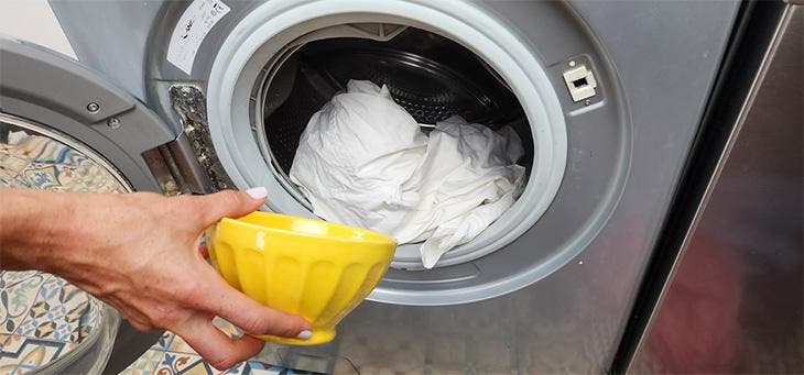 Verser une tasse de bicarbonate et sel dans le lave-linge
