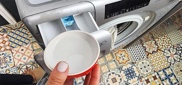 Verser une tasse de vinaigre dans le lave-linge