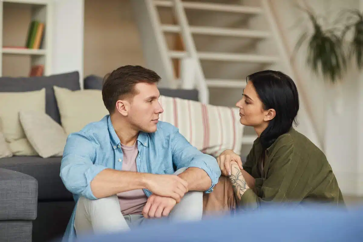 Couple discutant avec authenticité dans un intérieur chaleureux