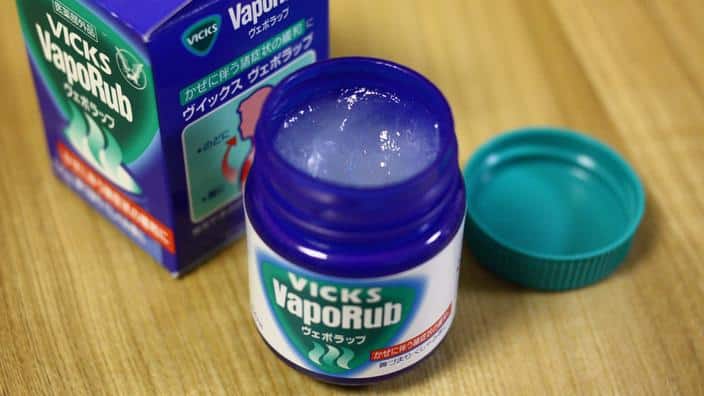 Fiole de Vicks VapoRub pos&eacute;e sur une table