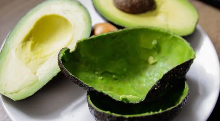 Avocat coupé en deux montrant sa chair et sa peau