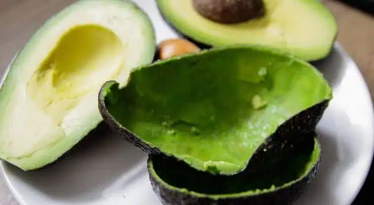 Avocat coupé en deux montrant sa chair et sa peau