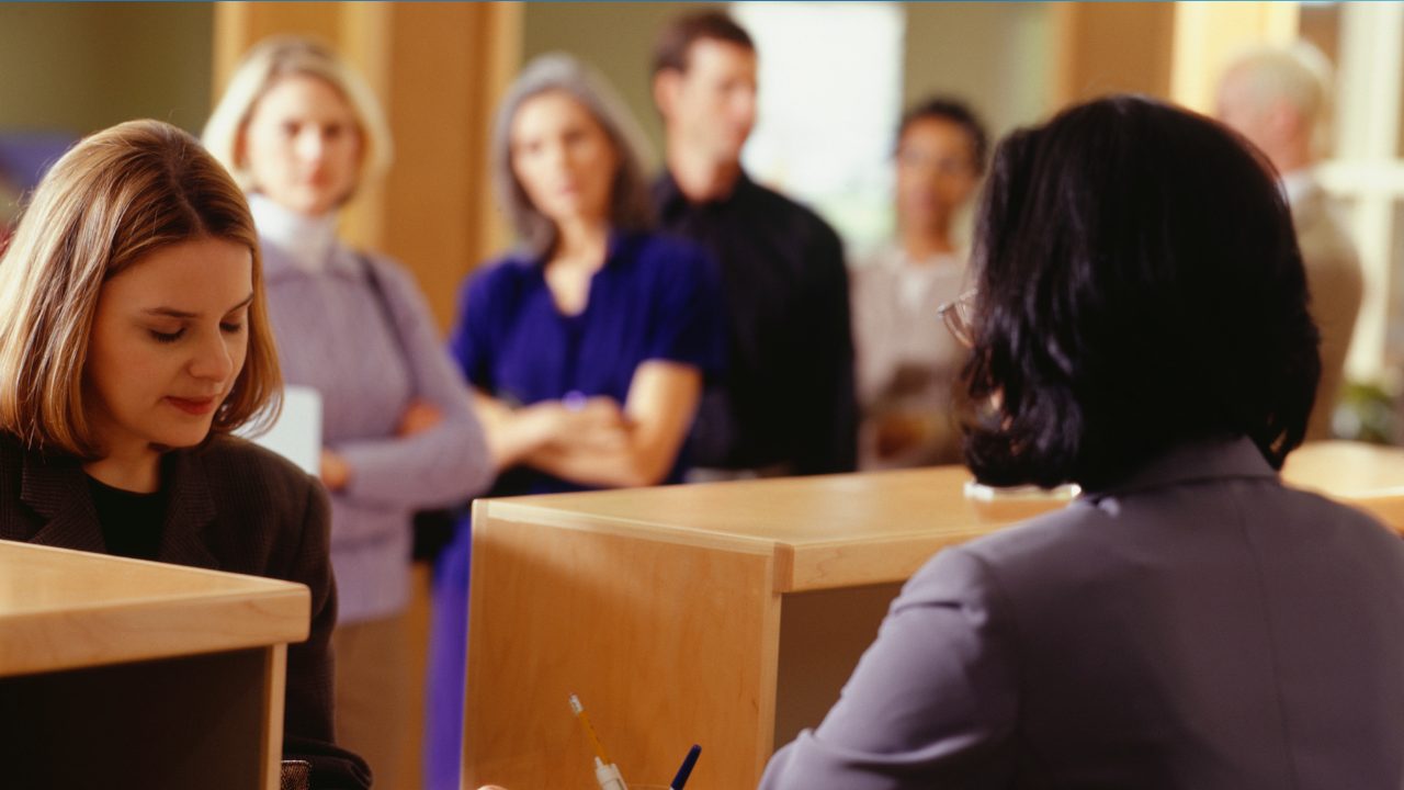 Une femme &acirc;g&eacute;e sortant d'une agence bancaire