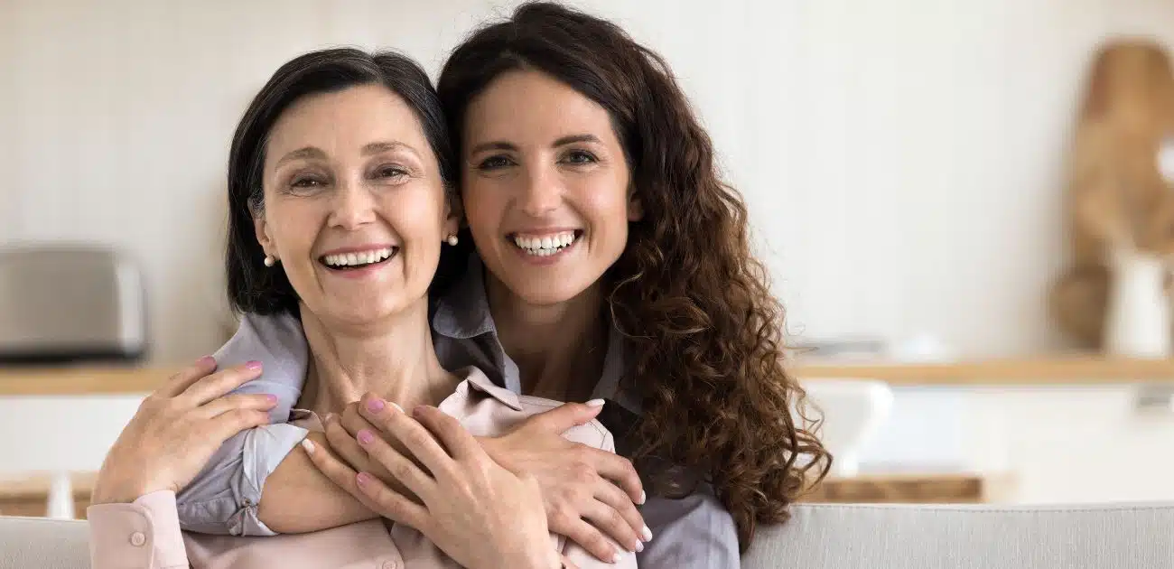 Mère aidant son fils adulte dans une tâche quotidienne, sourires aux lèvres