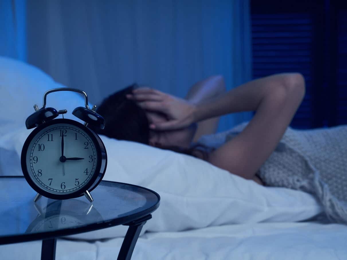 Personne dans son lit, cherchant à se rendormir tôt le matin, dans une ambiance calme