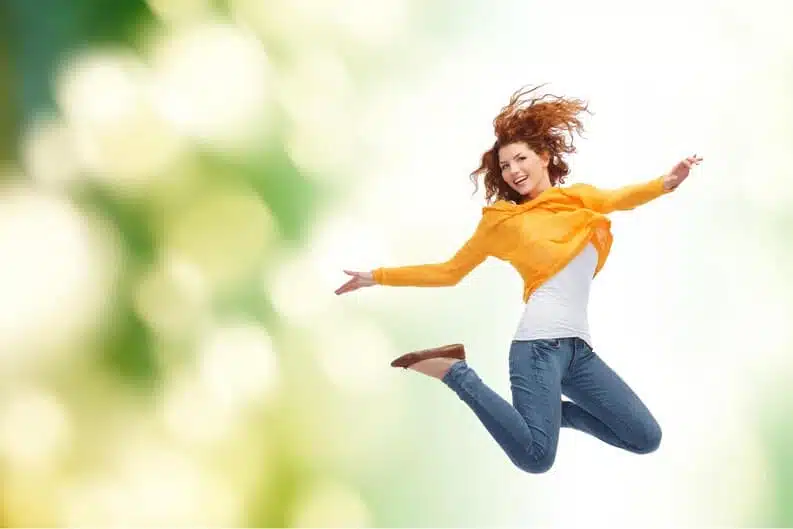 Jeune femme heureuse sautant