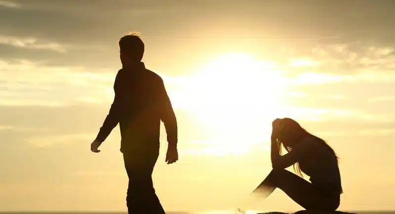 couple en silhouette se séparant au coucher de soleil