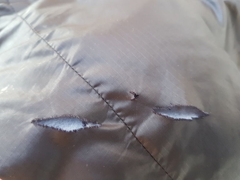 D&eacute;tail d'une d&eacute;chirure sur une doudoune