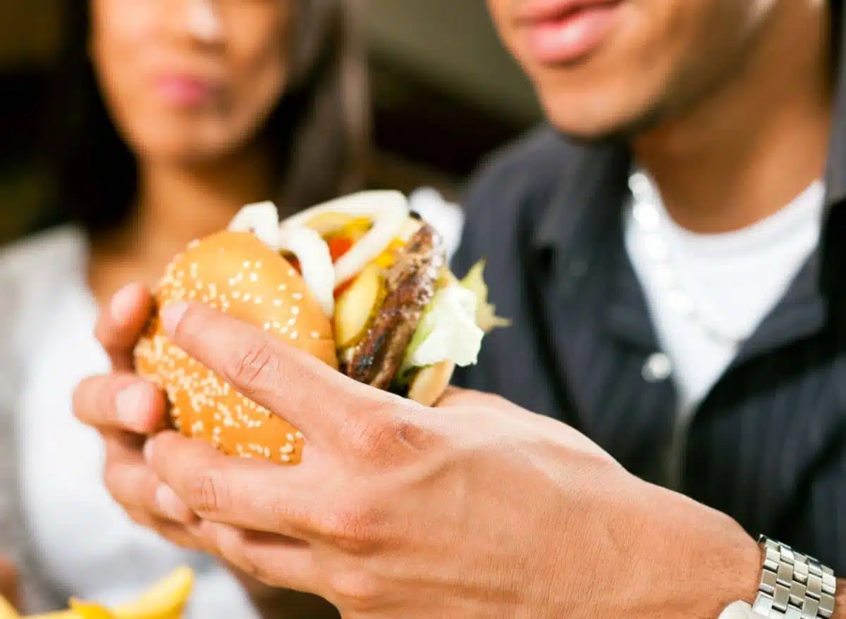 Personne mangeant un hamburger dans un fast-food