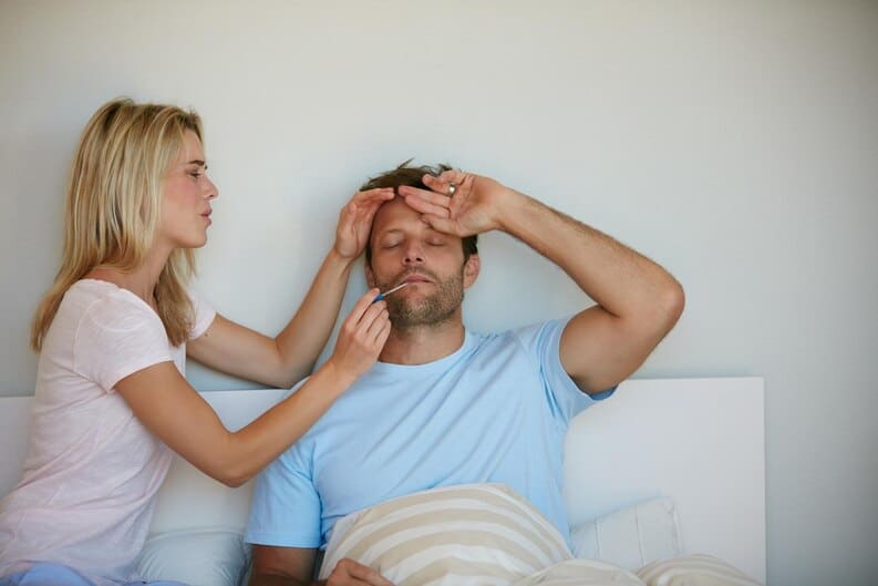 Femme prenant la température de son conjoint avec tendresse