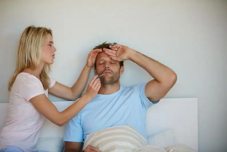 Femme prenant la température de son conjoint avec tendresse