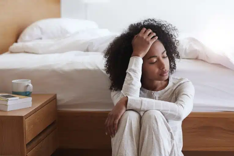 Femme épuisée s'appuyant contre un mur