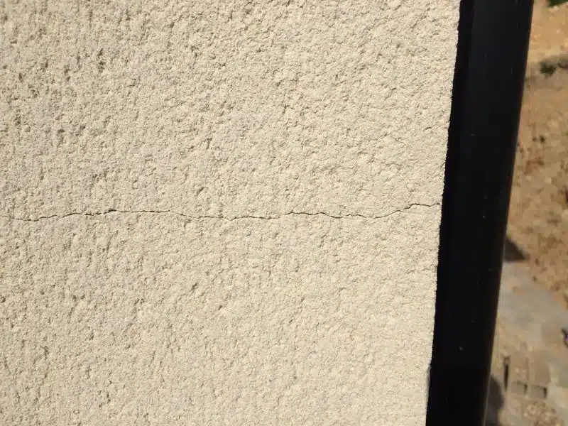 Fissure fine dans l'enduit d'un mur de maison