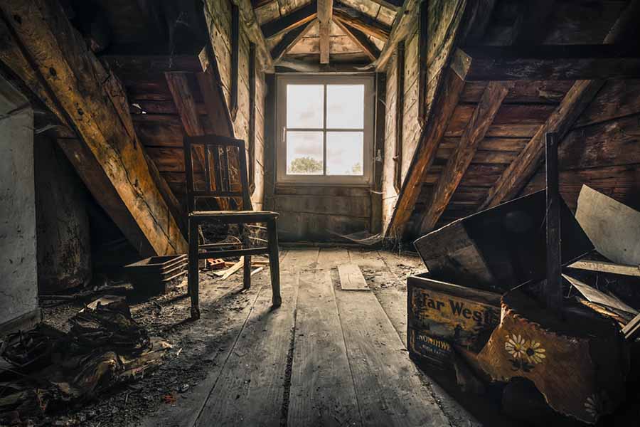 Int&eacute;rieur d'un grenier ancien avec des objets recouverts de poussi&egrave;re