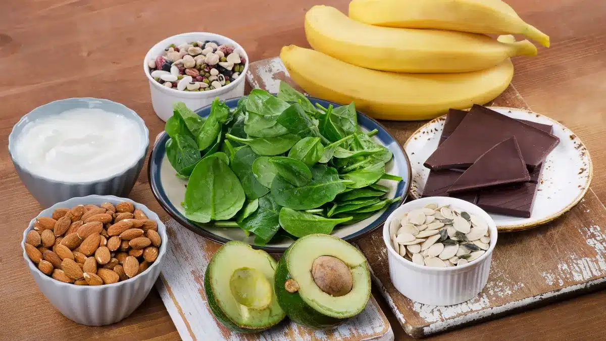 Assortiment d'aliments riches en magnésium : noix, légumes verts, chocolat