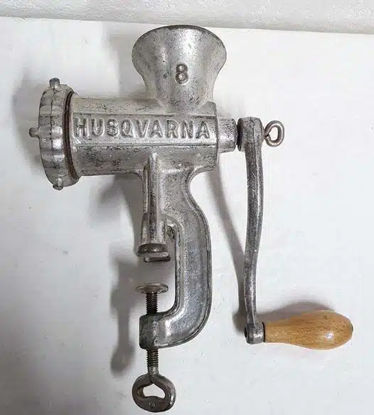 Photo d'un objet en métal ancien posé sur une table, qui s'est révélé être un hachoir à viande manuel