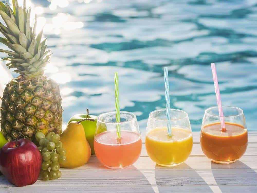 Verre de jus d'orange avec des fruits en arrière-plan