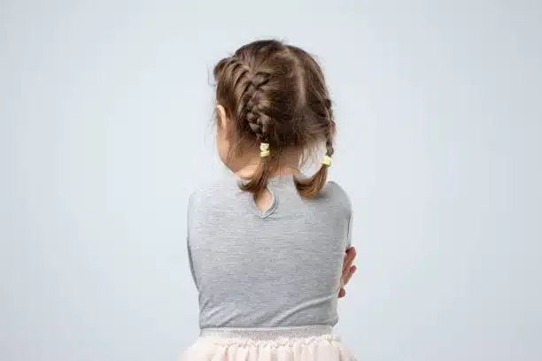 Enfant chuchotant à l'oreille d'un adulte